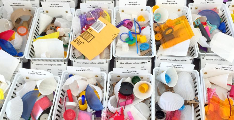 Baskets filled with found materials including bottle caps, bubble wrap, and cardboard.