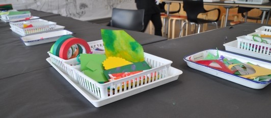 A supply basket filled with green paper, ready for guests to create with.