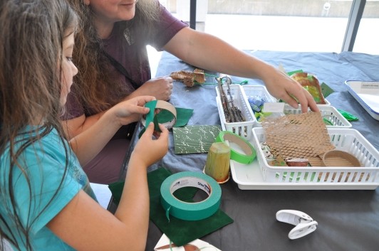 Guest coloring plain cardboard tubes with green tape