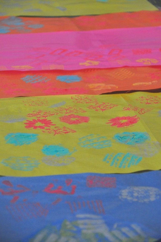 Stamped papers laying out to dry on table.