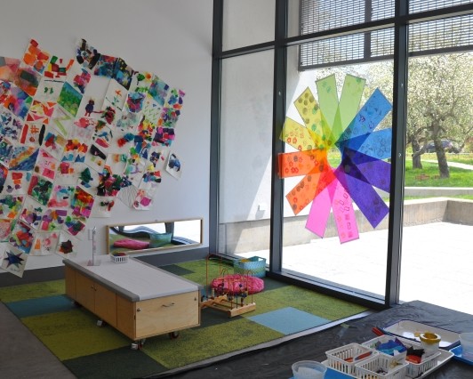 Display hung in toddler area next to a tissue paper display and above the carpeted area.